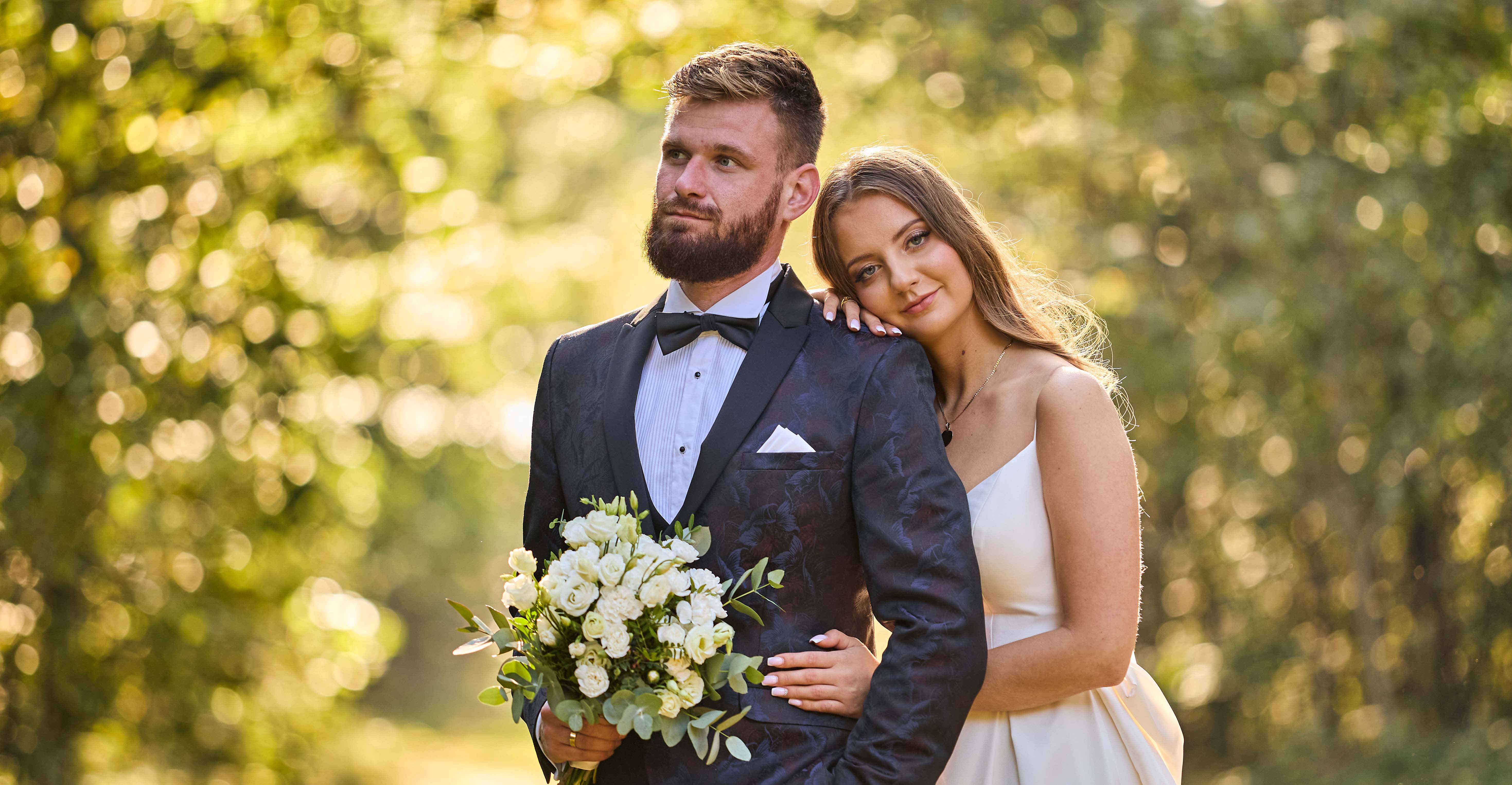 Młoda Para w lesie pośr&oacute;d majesttycznych drzew. Promienie słonca przebijają si eprzez liście drzew, tworząc magiczną armosferę.